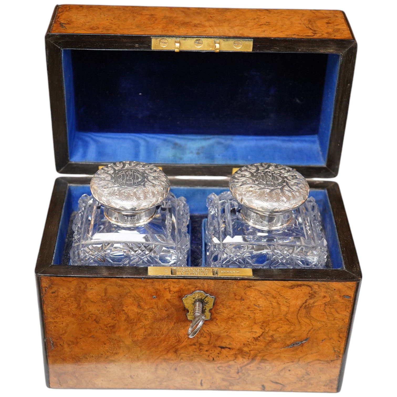 A Victorian burr walnut cased pair of silver topped perfume bottles, retailed by Piesse and Lubin, 11cm high. Condition - box cracked at the top/side, bottles good